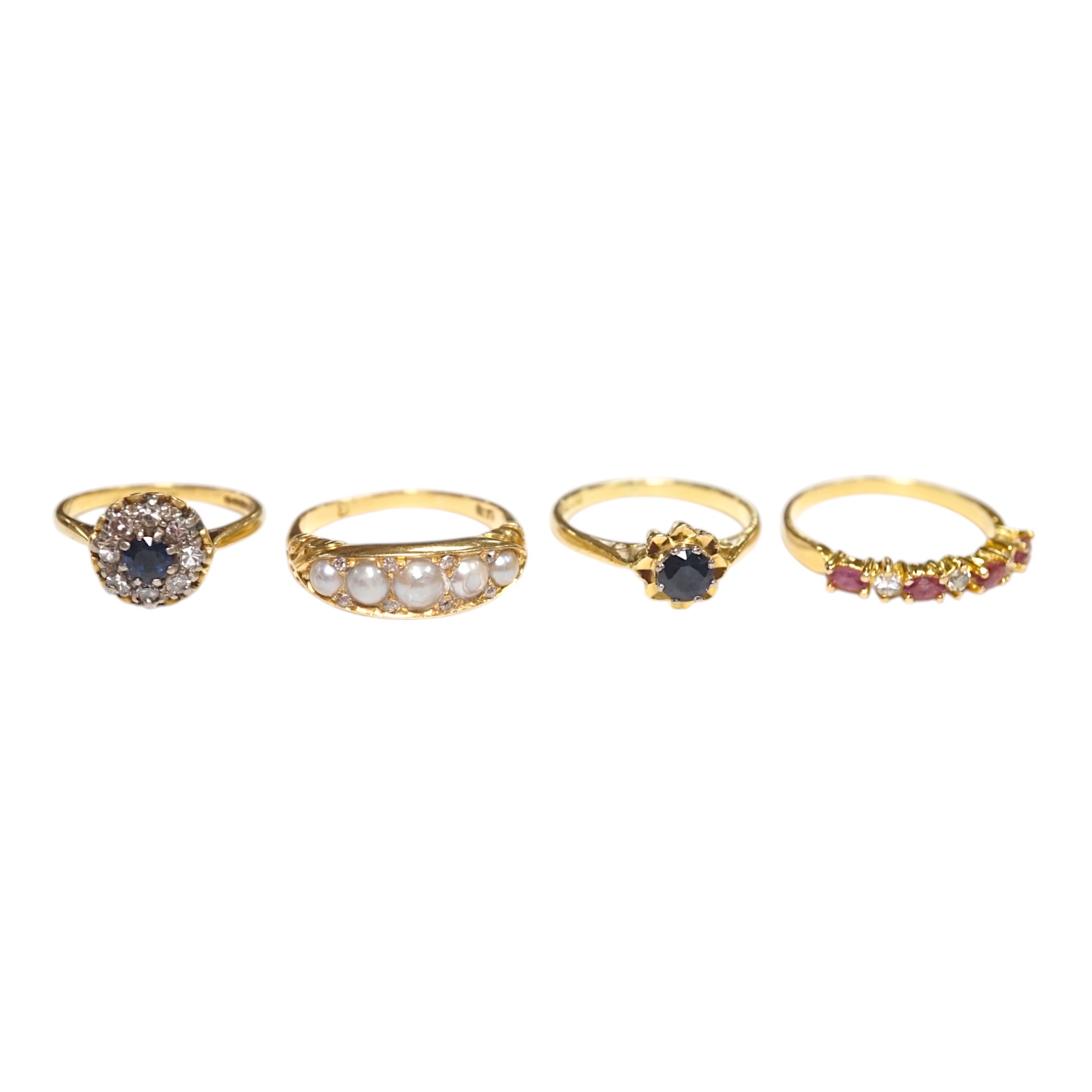 A late Victorian yellow metal and five stone split pearl set half hoop ring, with diamond chip spacers, size N/O, two modern 18ct gold and gem set rings and one other ring. Condition - fair to good